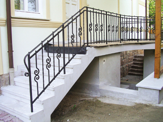 A korlátfogó idomra hengerelt acélból készült elegáns ívű és csavart pálcák, kosarak és kettős csigák visszafogott mívességet adnak ennek a korlátnak